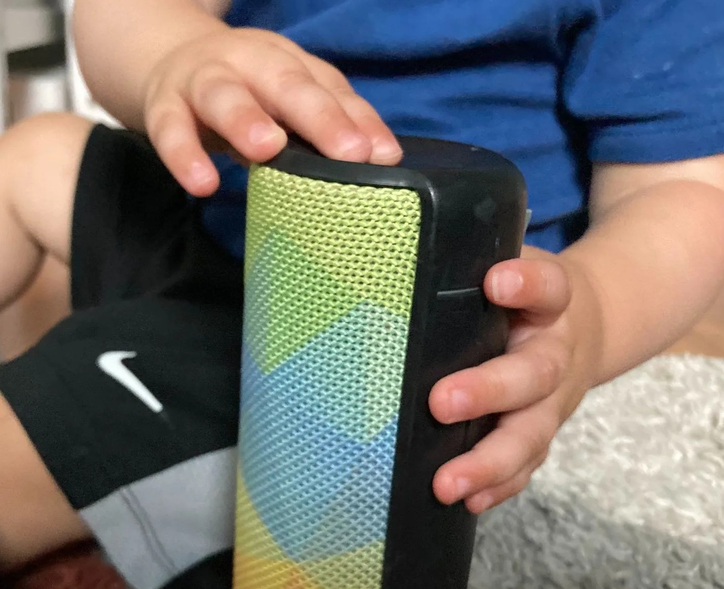 a baby pressing buttons on a ue boom