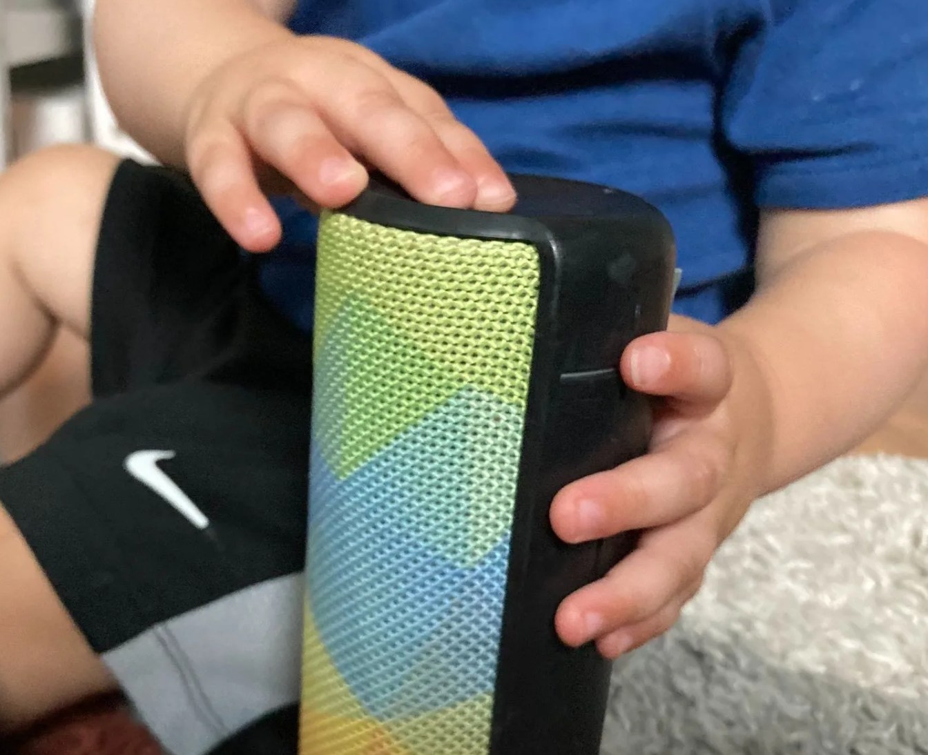 a baby pressing buttons on a ue boom