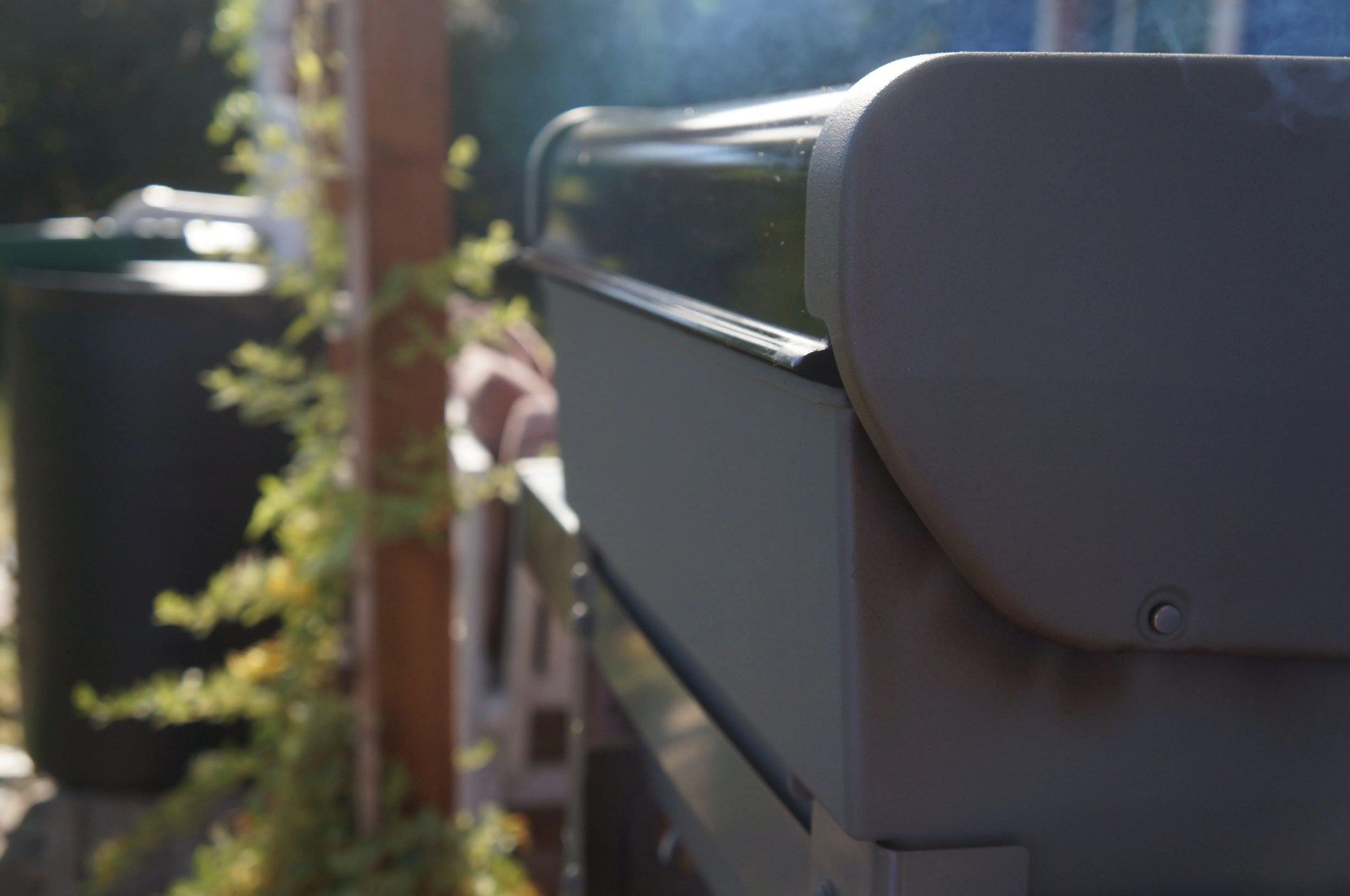 blue smoke gently floating out of the rear vent on the weber spirit