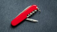 red swiss army knife on blue denim background