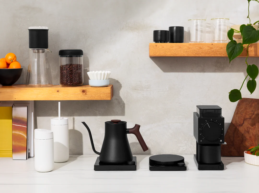 a kitchen counter with coffee cups and coffee maker