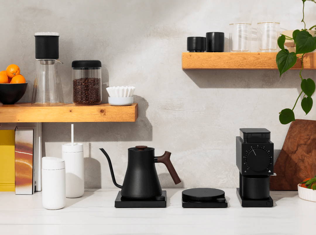 a kitchen counter with coffee cups and coffee maker