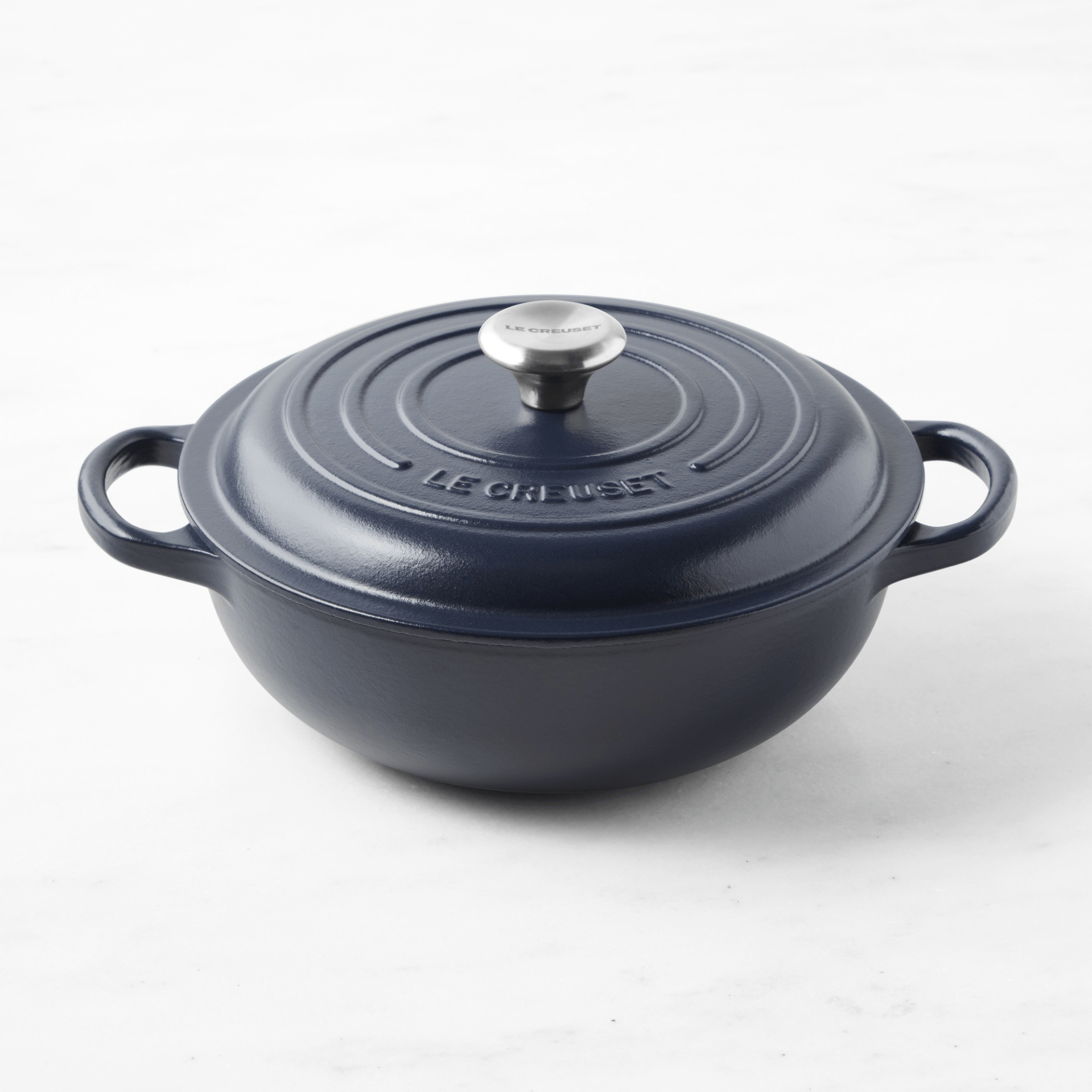a black teapot on a white surface