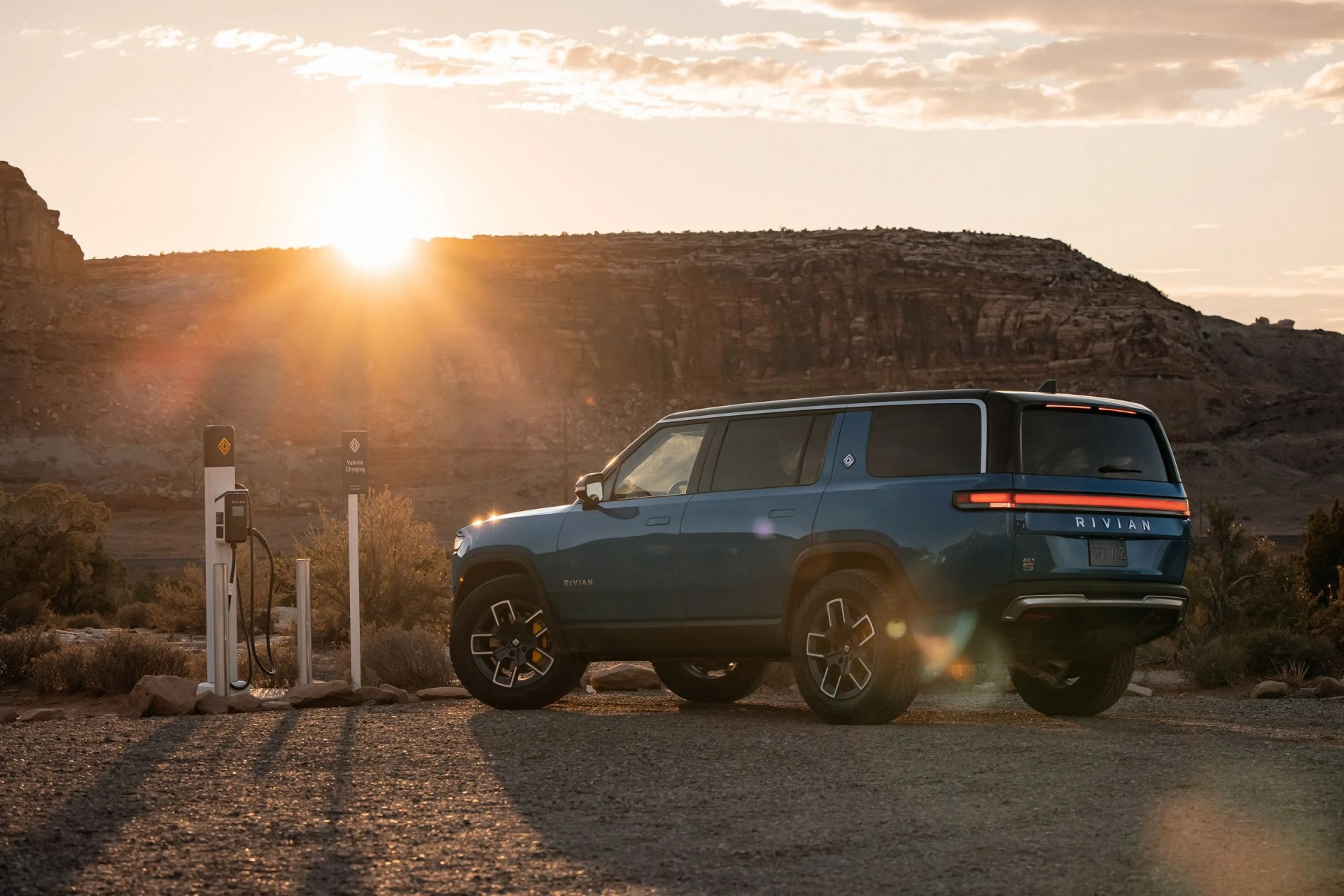a car parked on a road with a sunset in the background