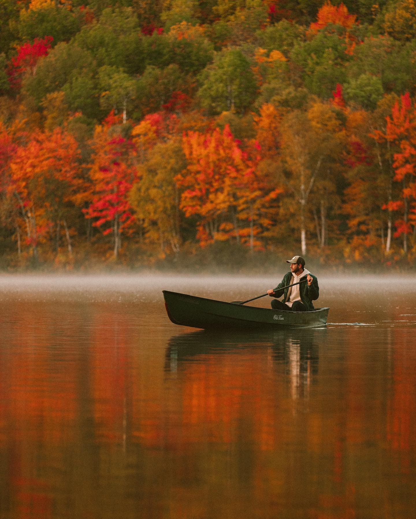 man rowing a boat in fall