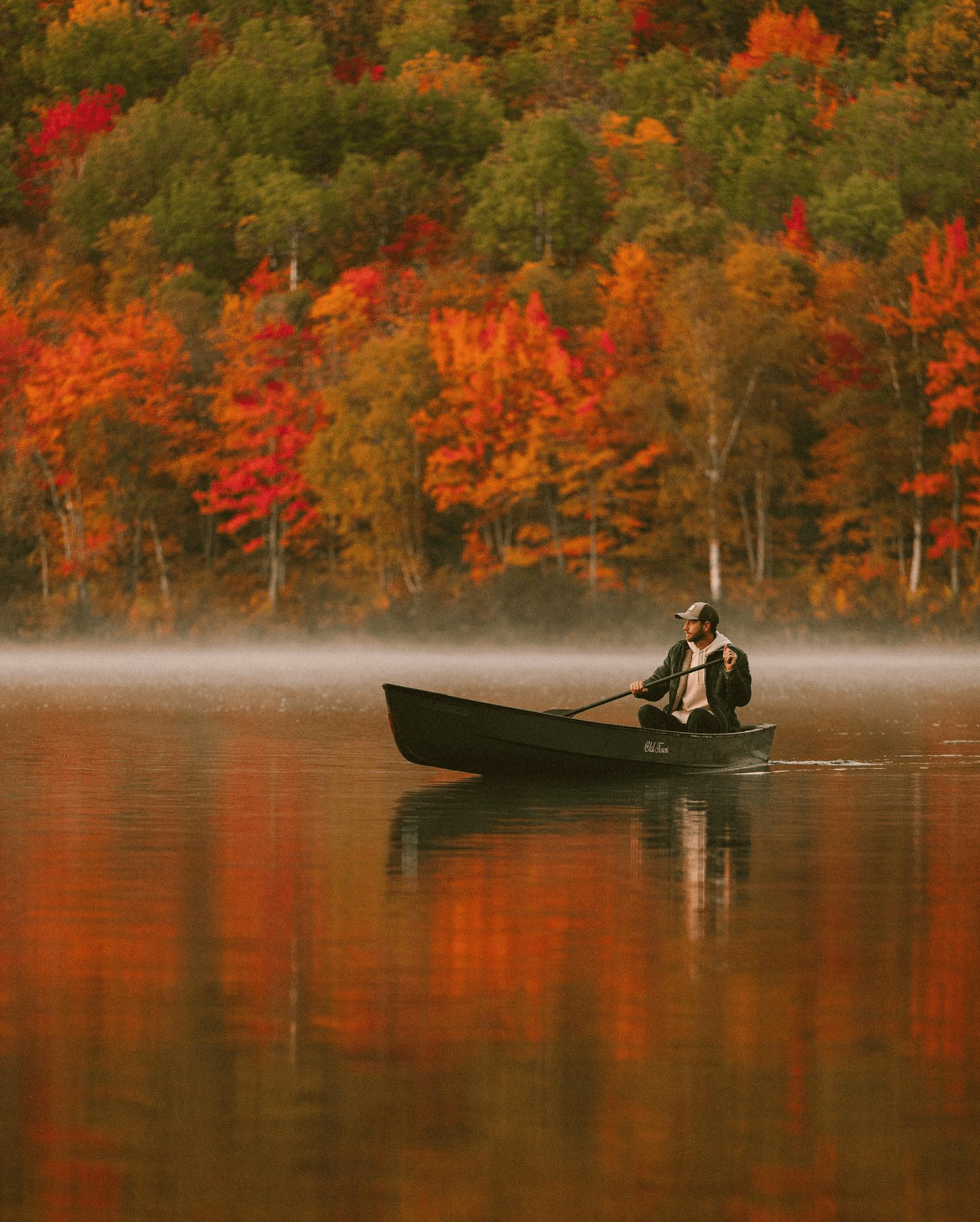 man rowing a boat in fall