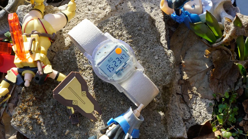 CW&T solid state watch sitting on ground next to other strange pieces of debris