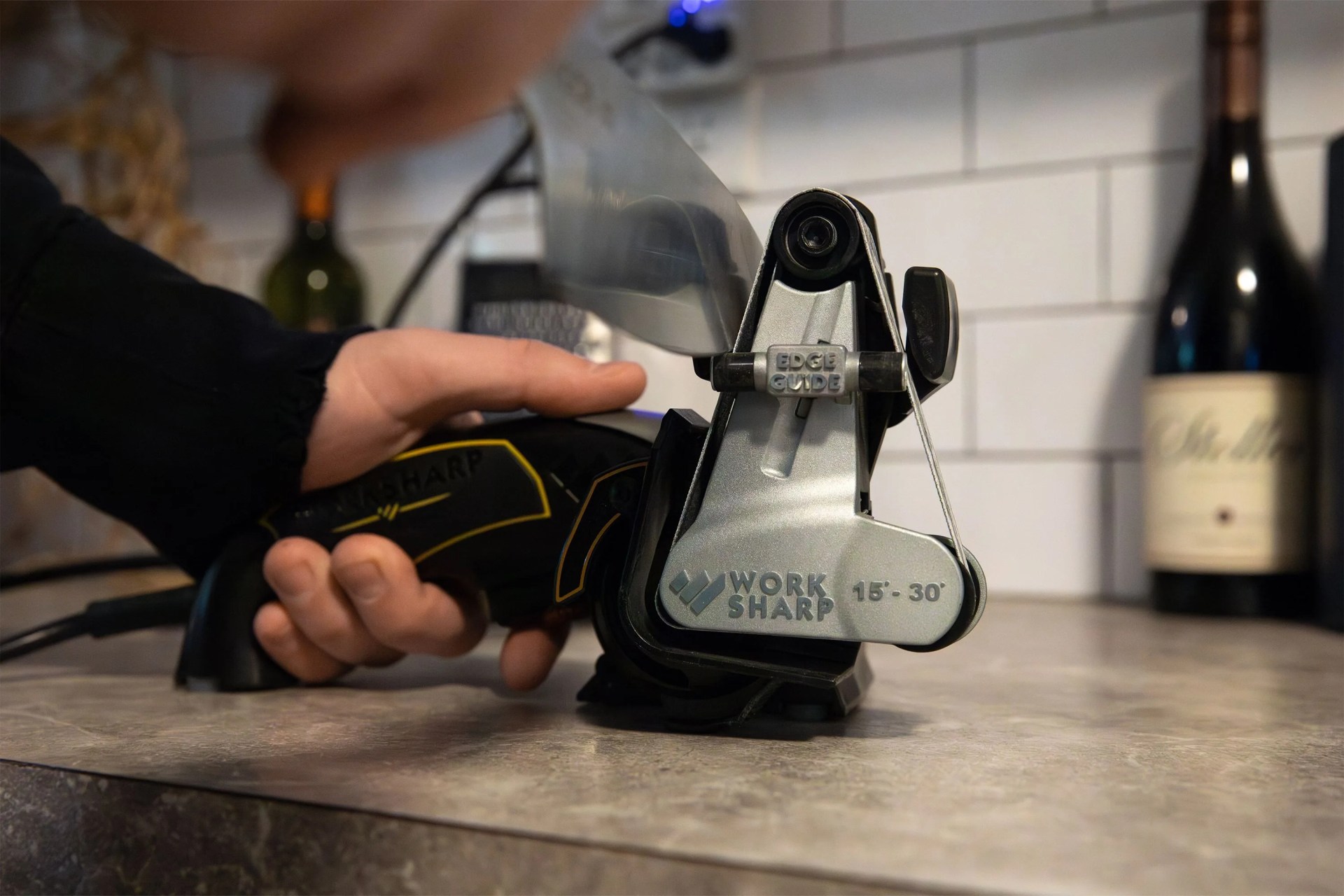 a person sharpening a knife on a counter