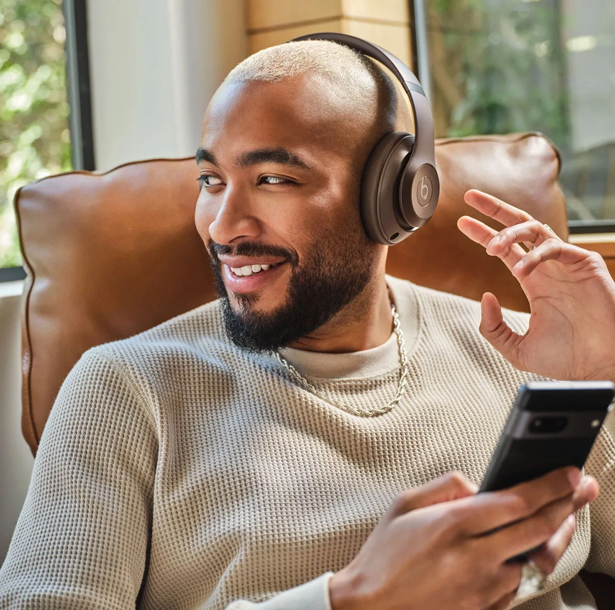 a person wearing headphones and holding a phone