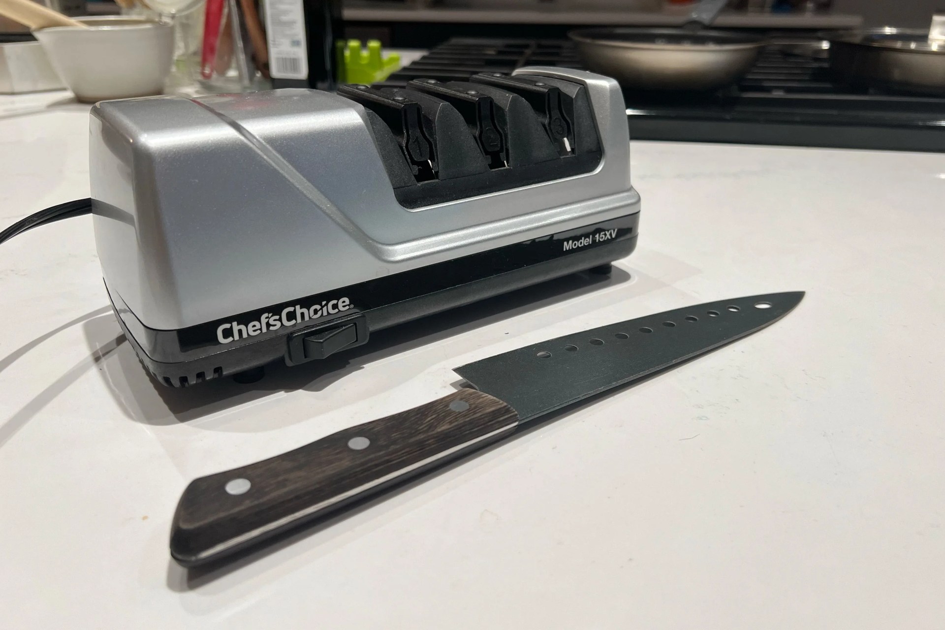 a knife on a table next to an electric knife sharpener