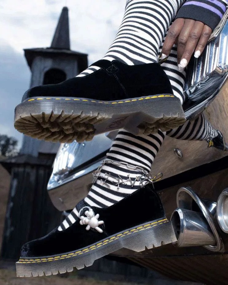 a person's feet wearing dr marten shoes