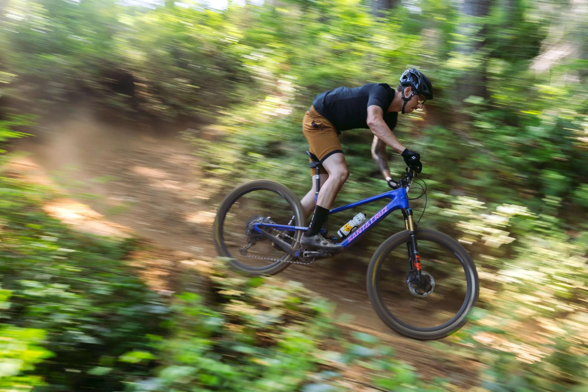 a man riding a bike on a trail in the woods