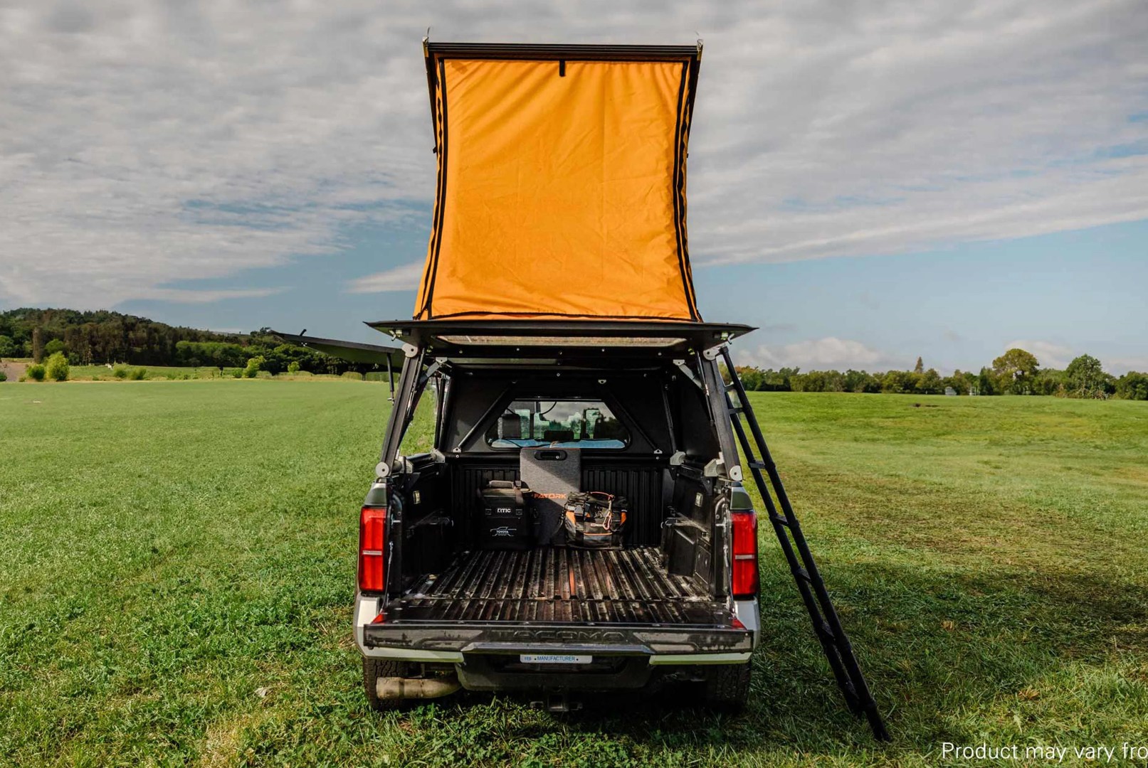 tacoma truck with a camper in a field