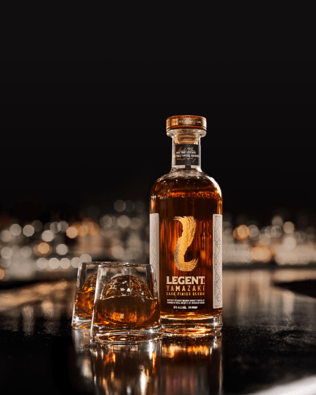 a bottle of suntory legend yamazaki limited edition bourbon and a glass of bourbon on a table