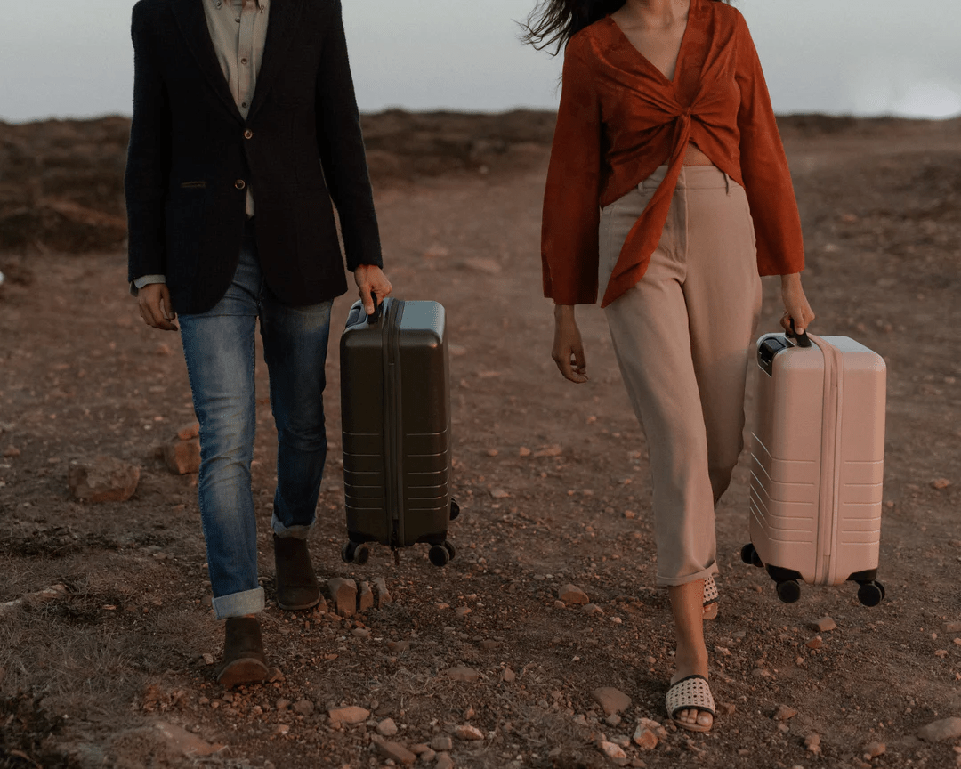 a man and woman walking with luggage