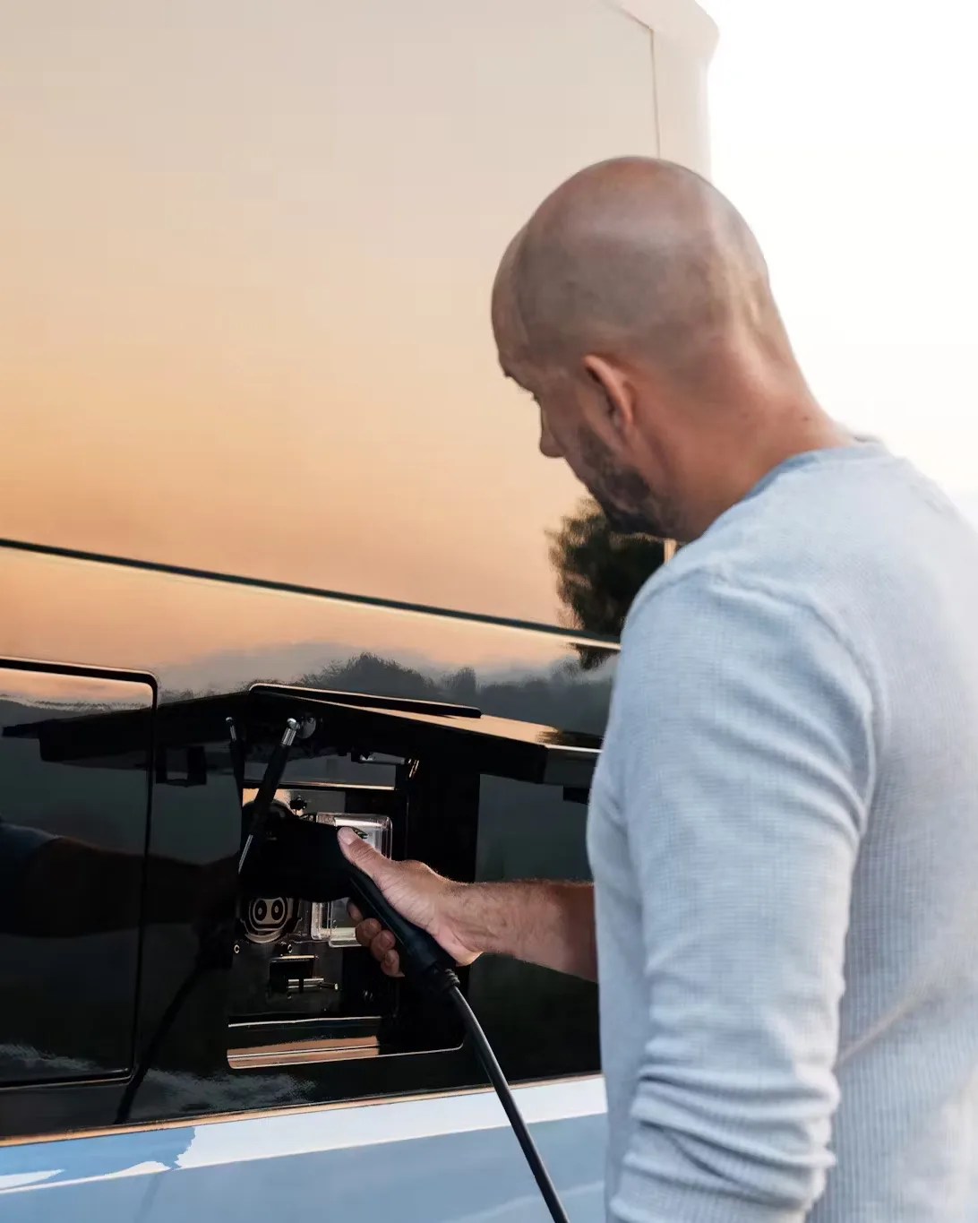 man charging an electric camping trailer