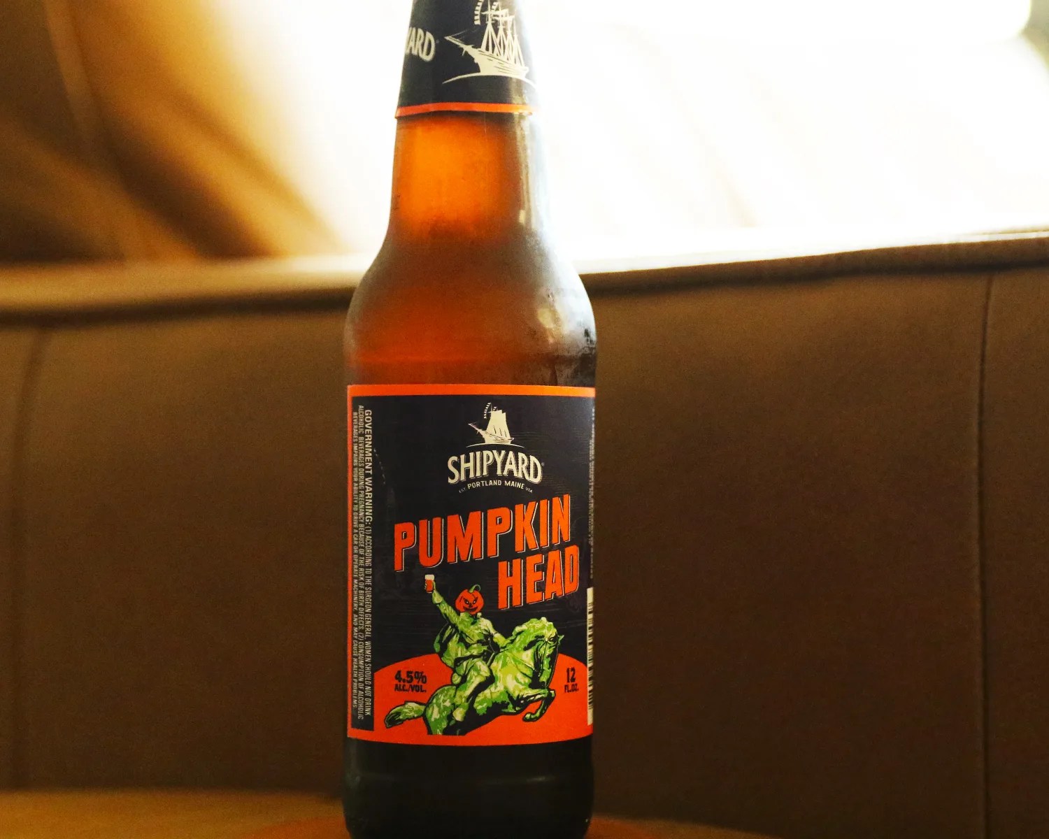 shipyard pumpkinhead beer bottle next to a couch