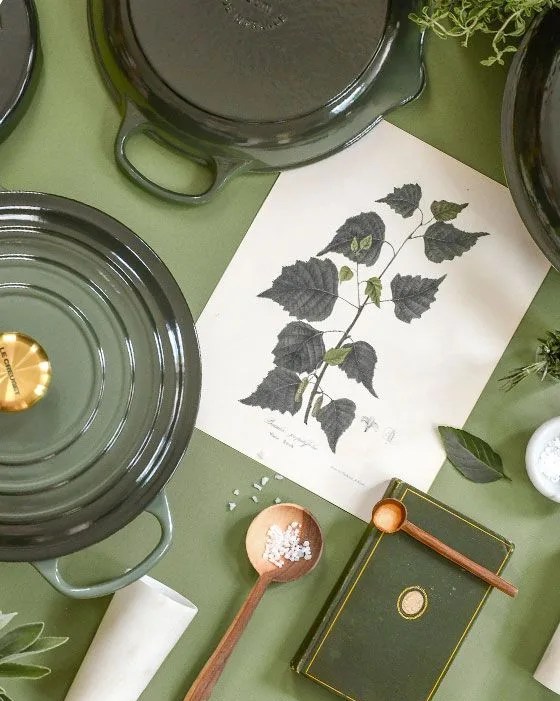 a table with plates and bowls from le creuset