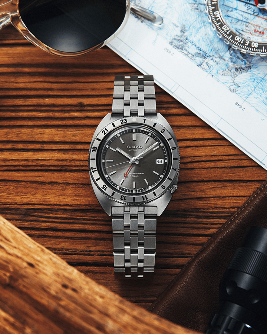 a silver watch on a wooden surface