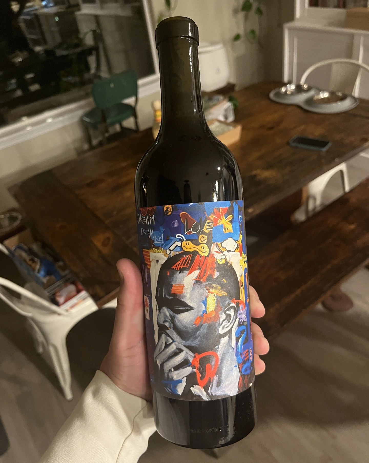 a hand holding a wine bottle