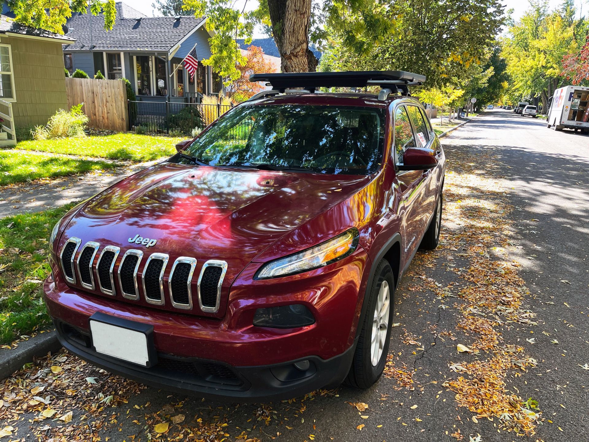 a red jeep parked on the side of a road