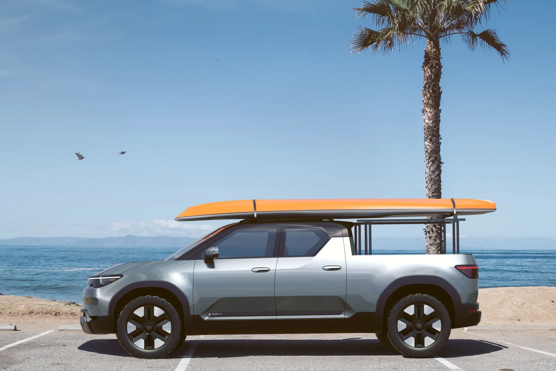 toyota electric pickup with surfboard on the roof