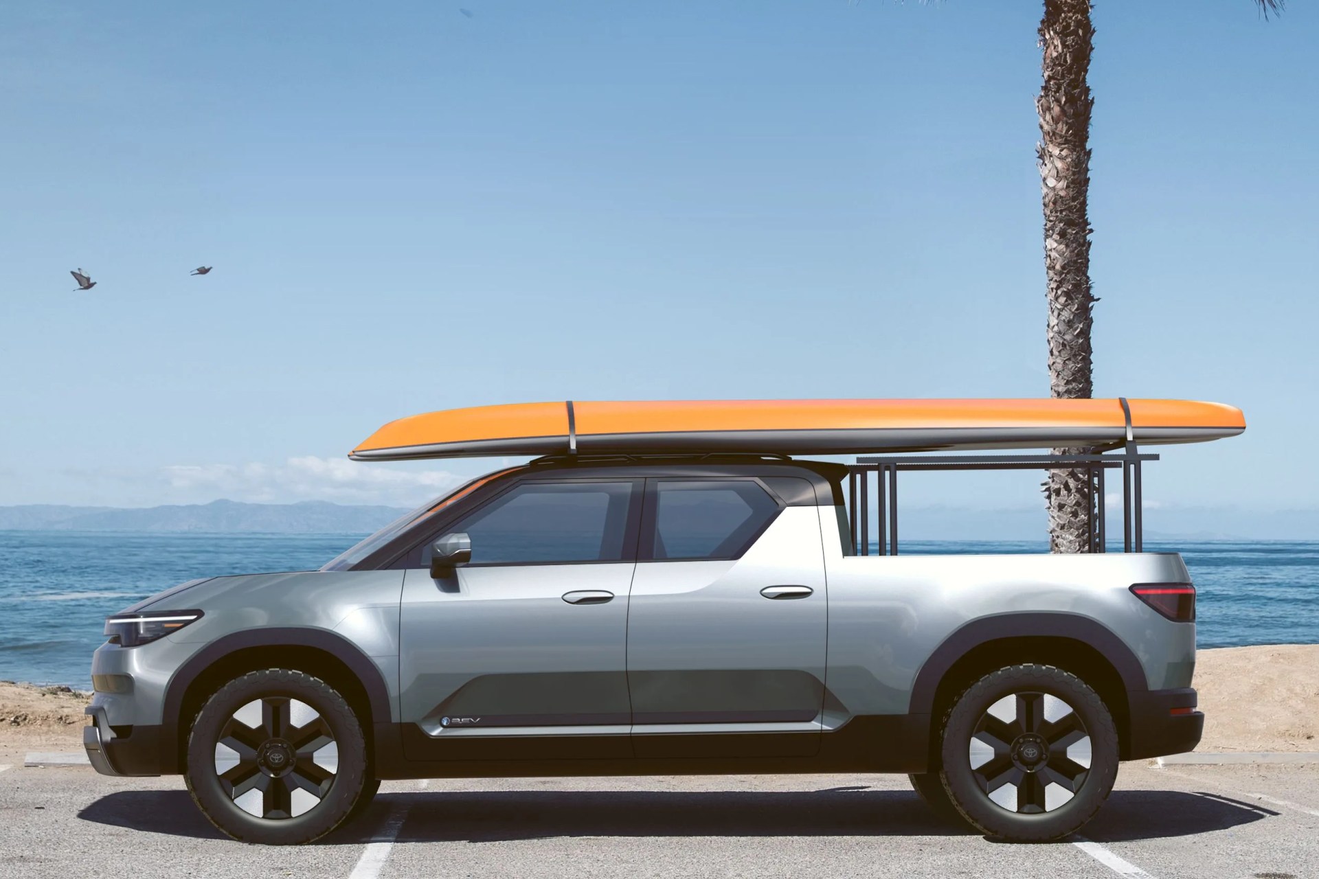 toyota electric pickup with surfboard on the roof