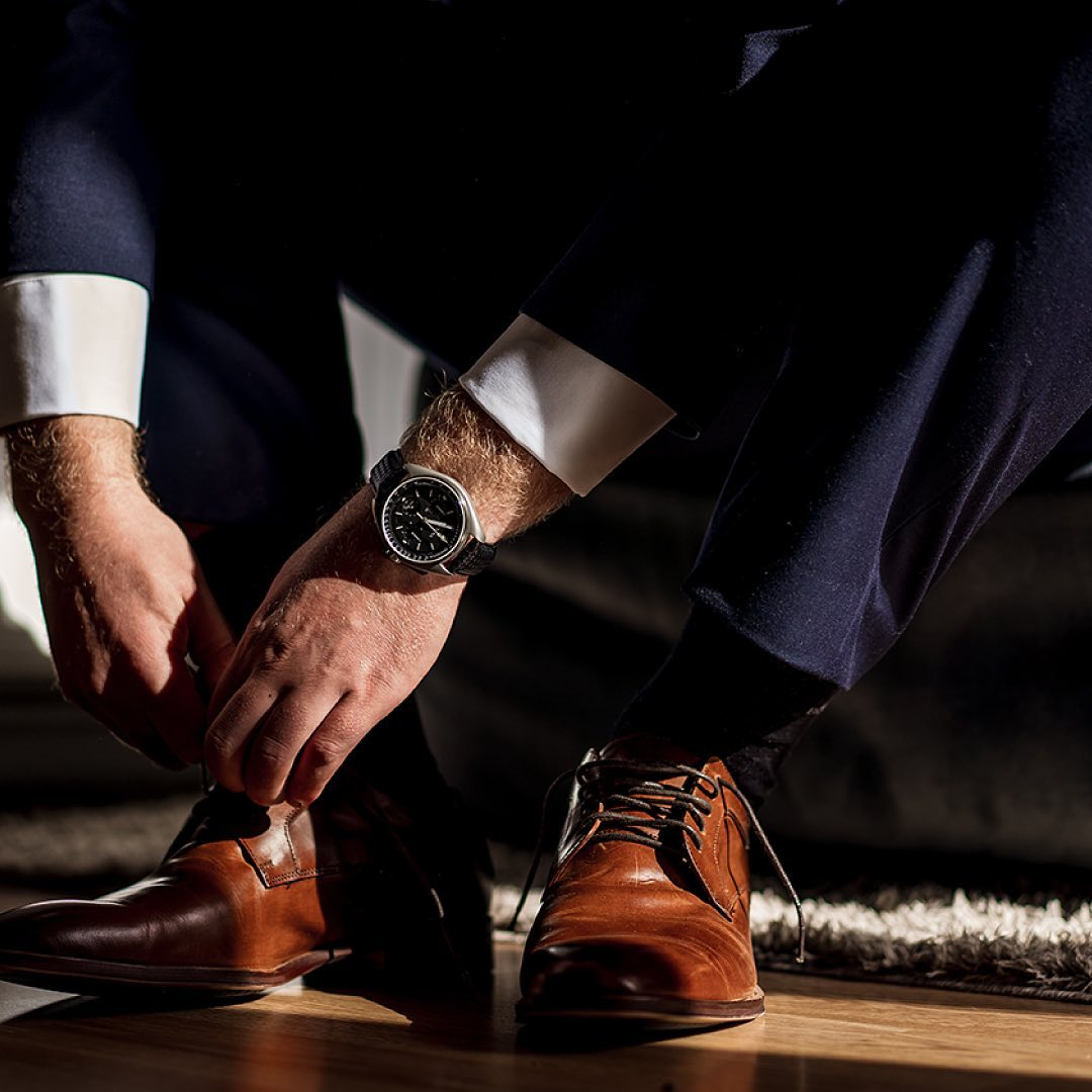 a pair of hands wearing black shoes