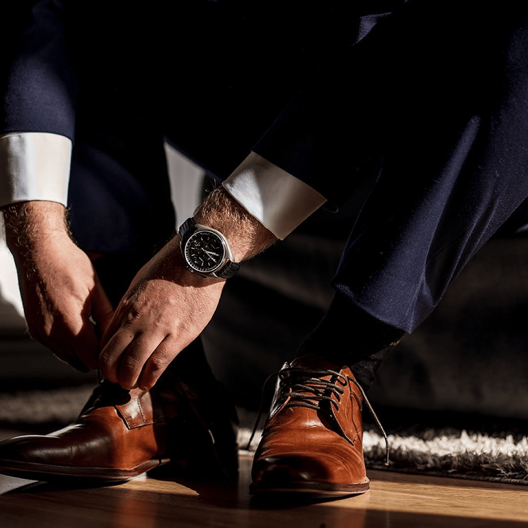 a pair of hands wearing black shoes