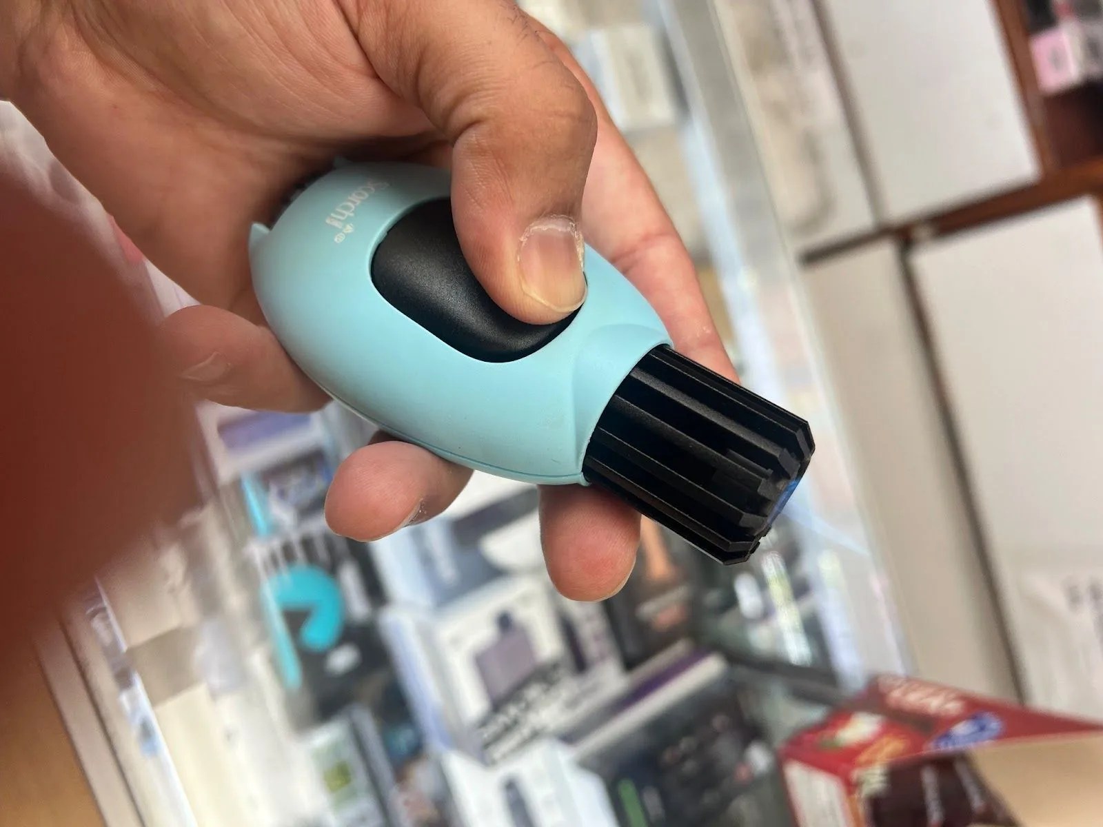 a hand holding a black and blue object