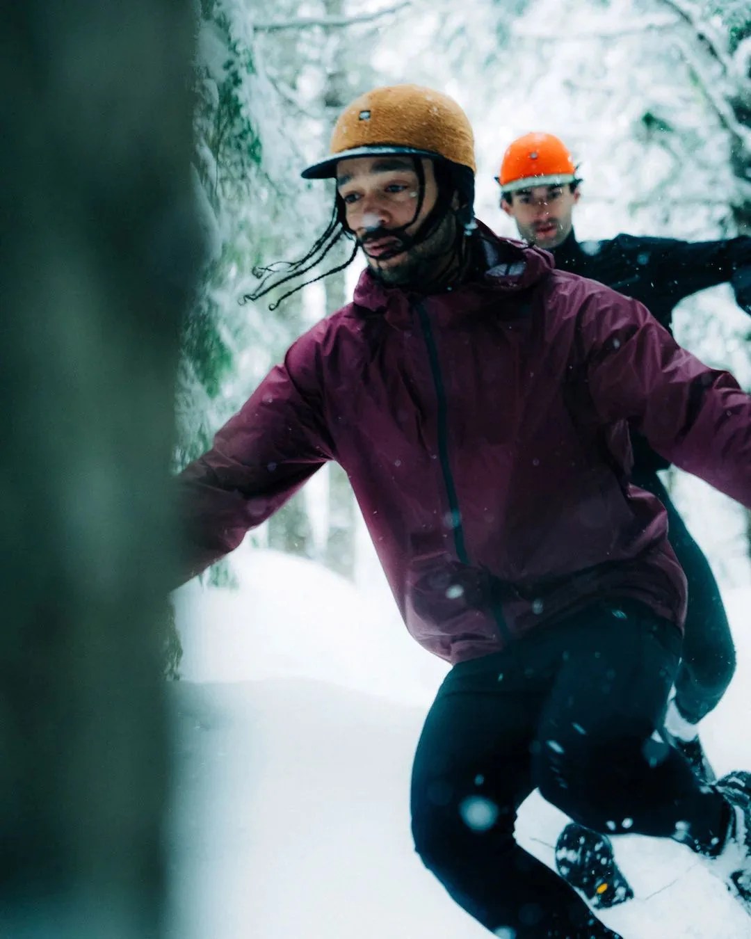 two men running through snow wearing kiel crwcap wnd sc