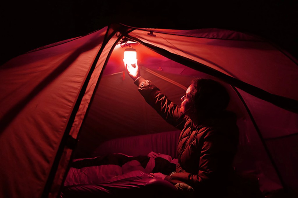 a person in a tent holding a light