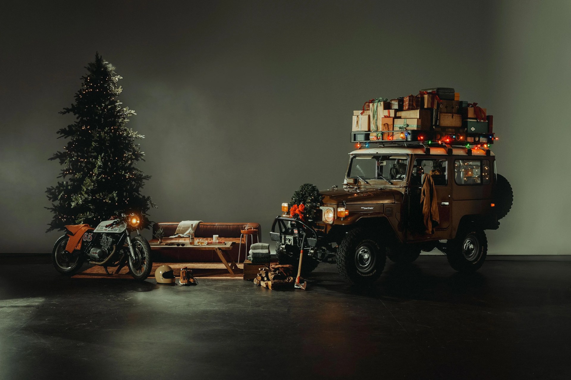 a christmas tree next to a motorcycle and couch with products laid out next to a car with presents piled on top