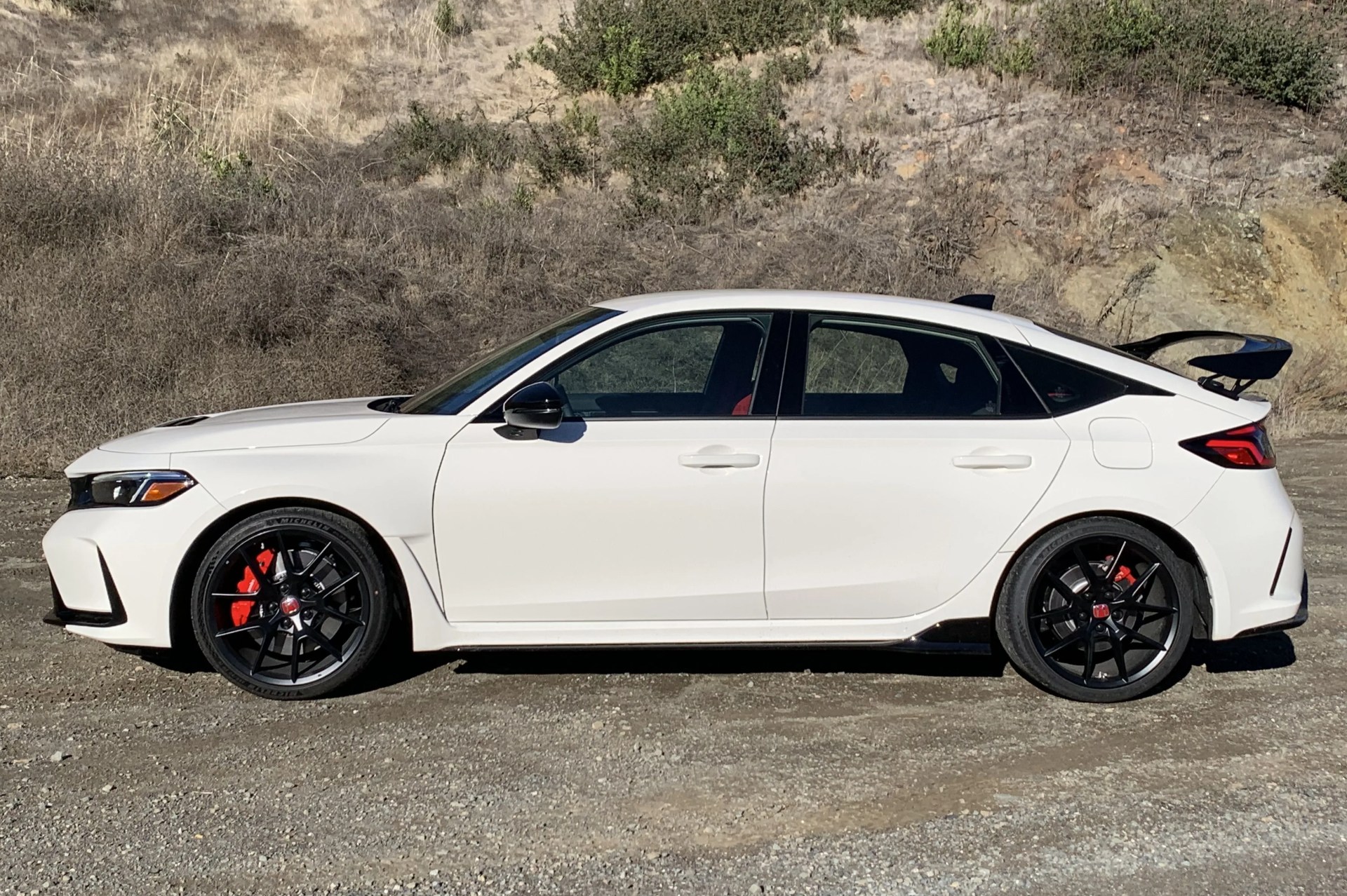 a white car parked on a dirt road