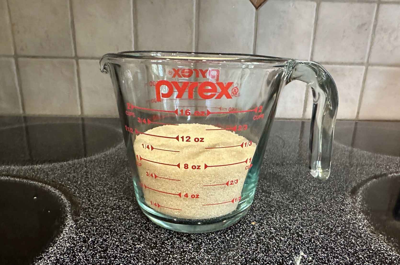 a measuring cup of sugar on a counter