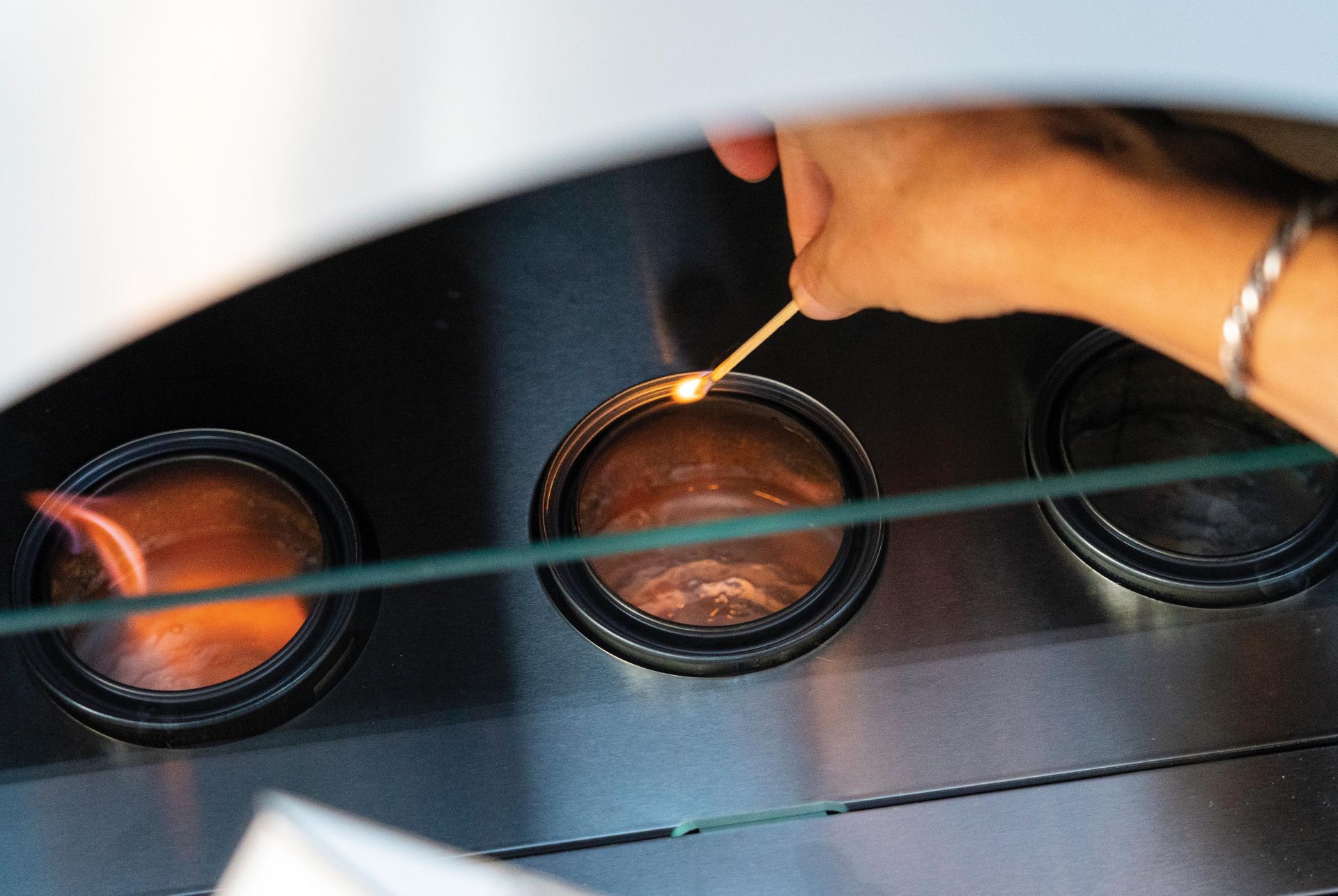 a person lighting a terraflame fire pit