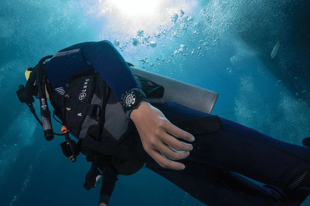 a person scuba diving and wearing a watch