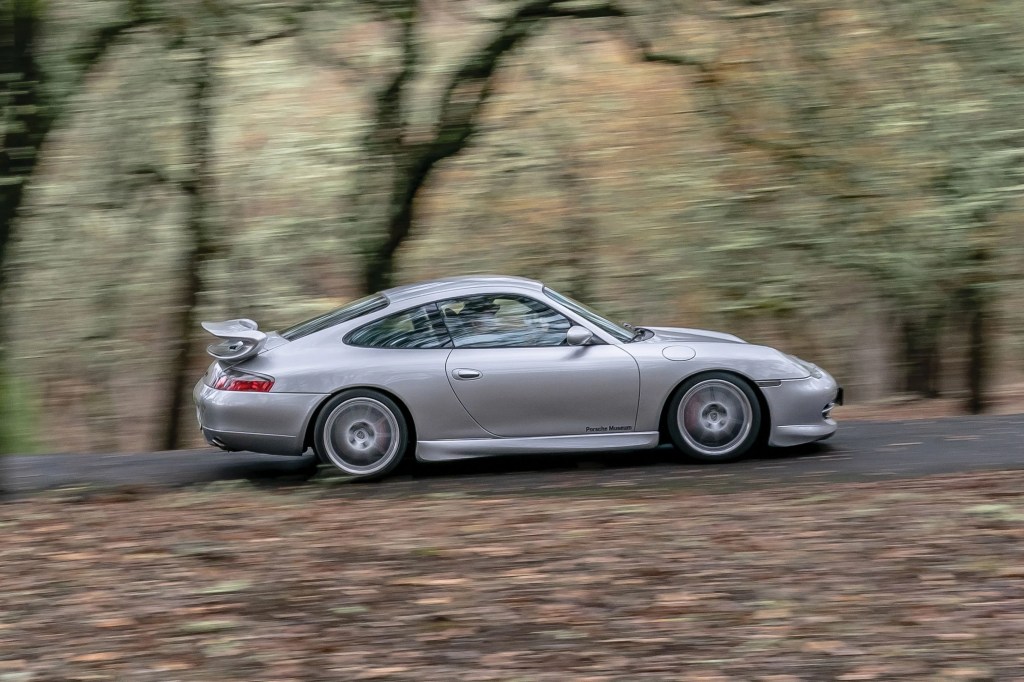 a porche 996 driving on a road