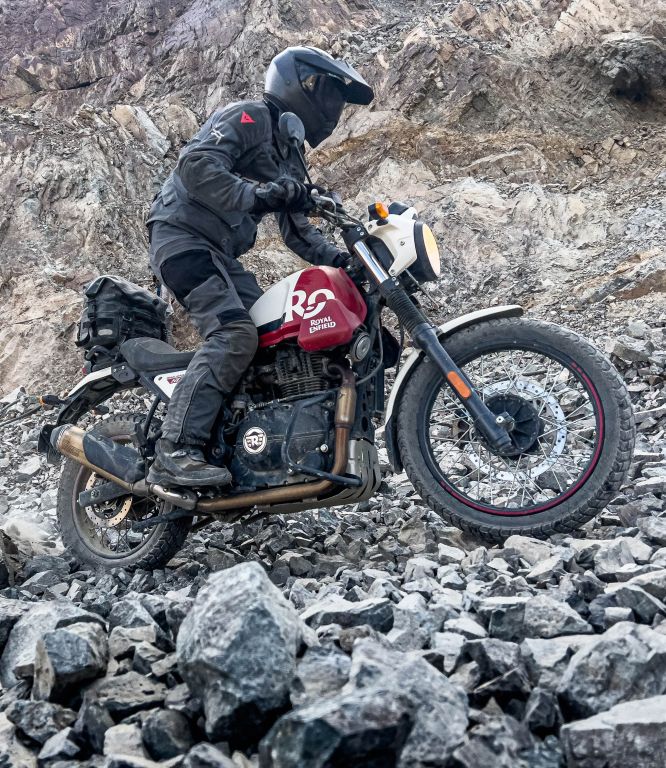 a person riding a motorcycle over rocks