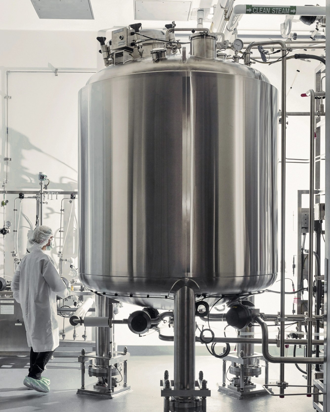 a person in a lab next to a metal tank