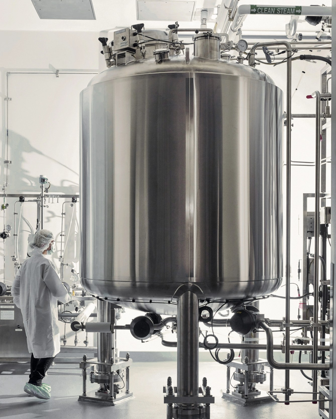 a person in a lab next to a metal tank