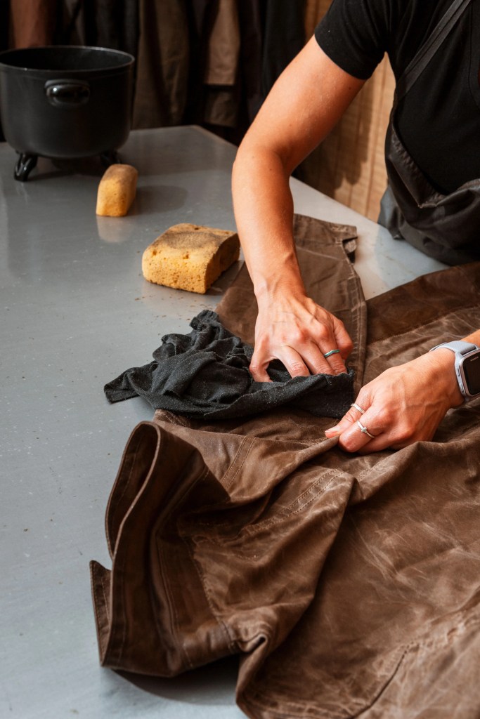 a person waxing a jacket