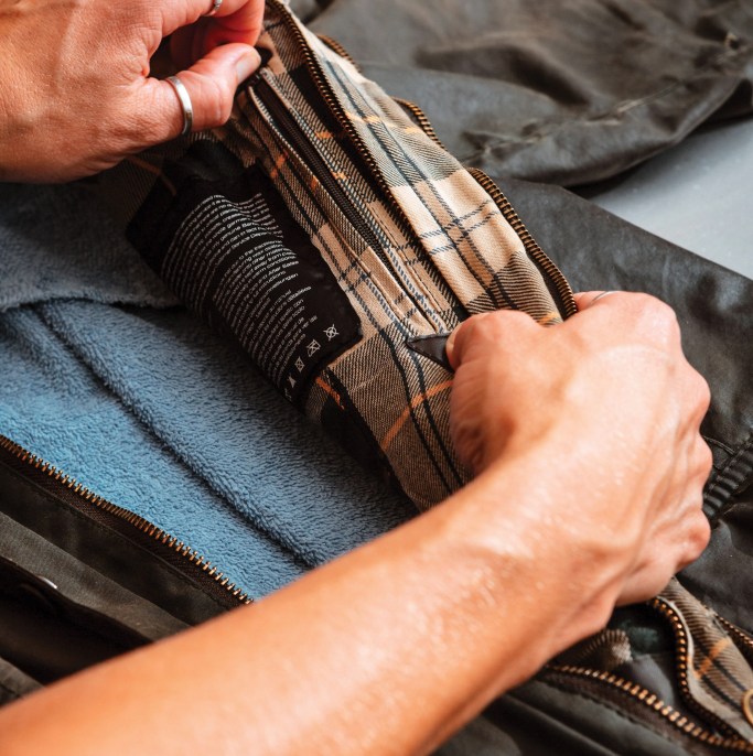 a close up of a woman zipping the inside of a jacket