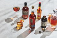 bottles of alcohol on a table with glasses of cocktails