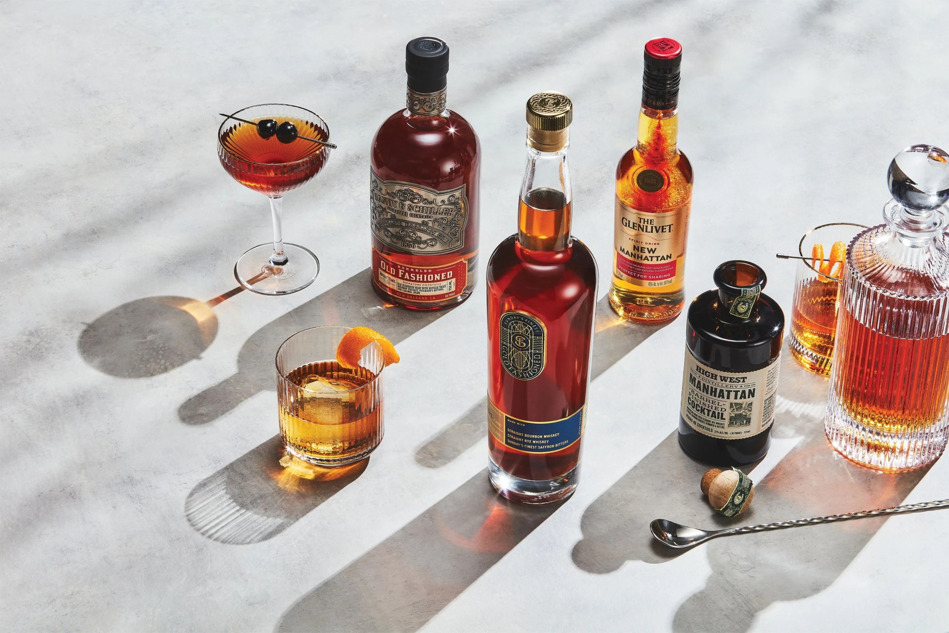 bottles of alcohol on a table with glasses of cocktails