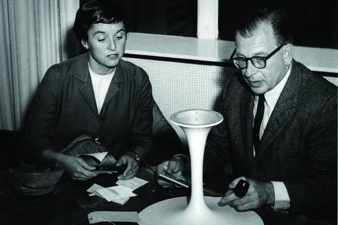 florence knoll and eero saarinen at a table with a design prototype