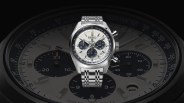 a silver watch with a black face