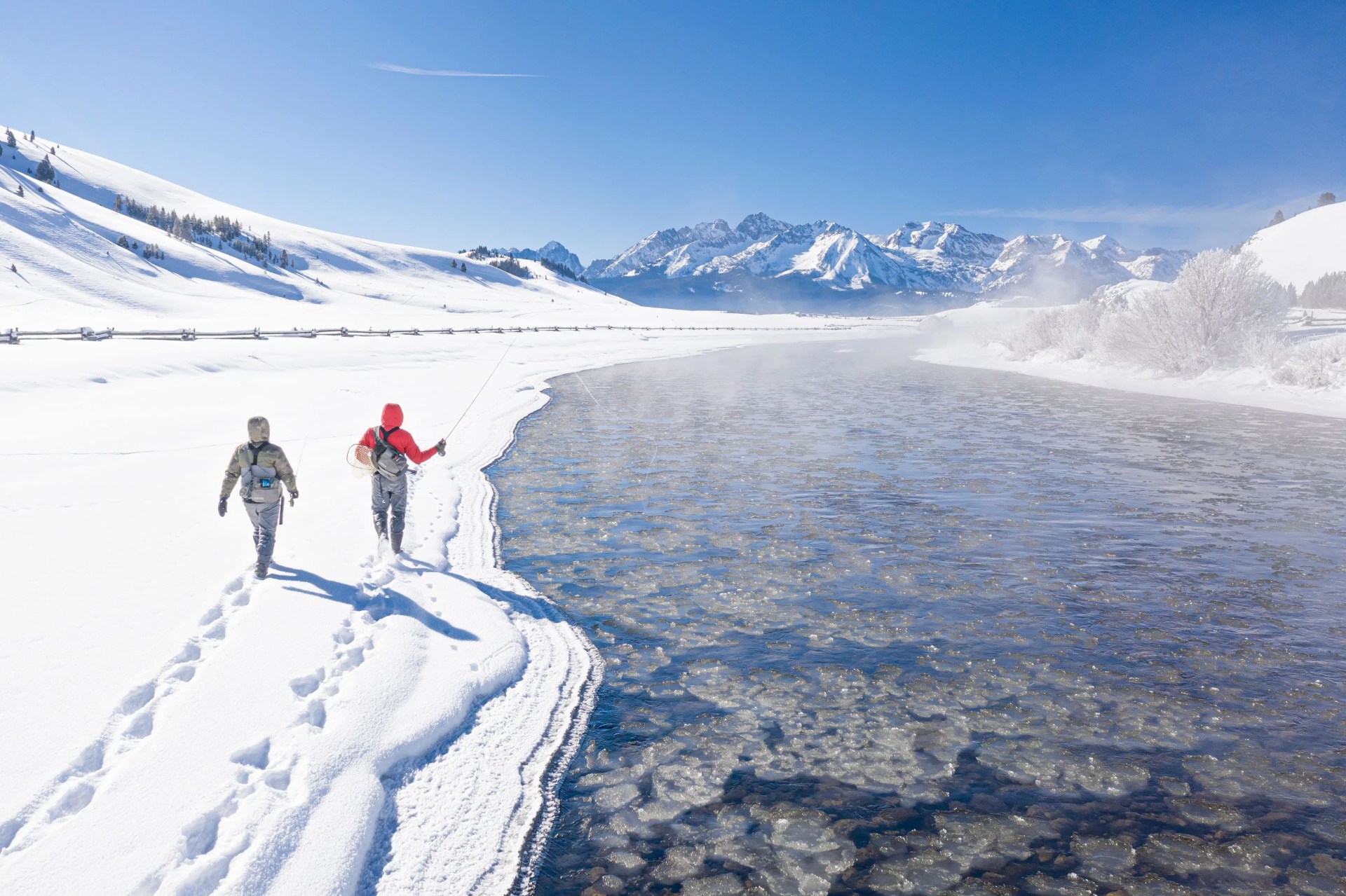 people walking on a snowy mountain with orvis fishing gear