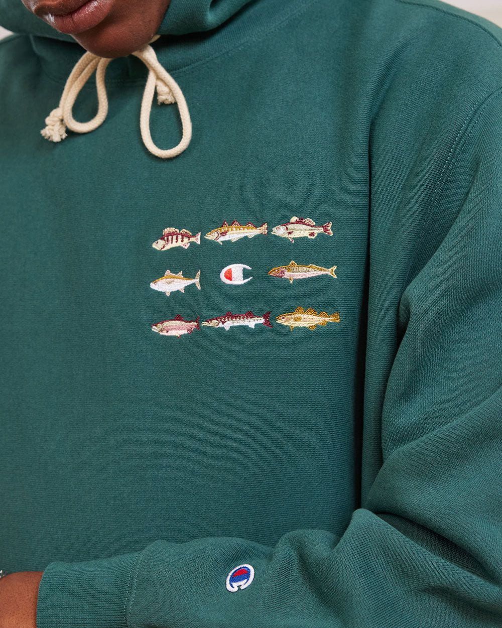 a man wearing percival rare fish hoodie by champion