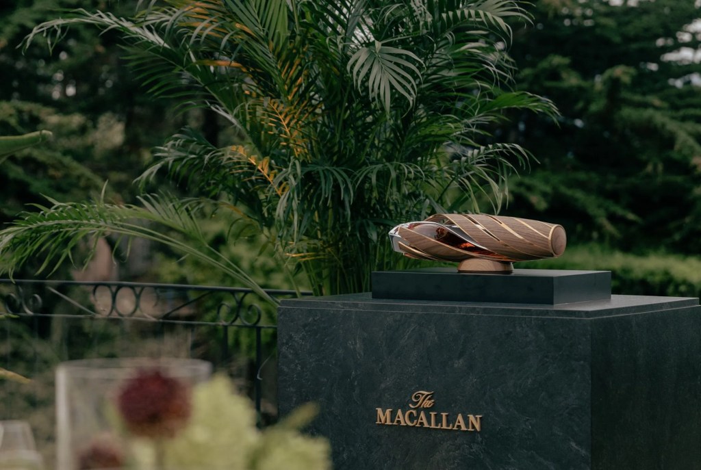 a bottle of the macallan horizon on a table with ferns in the background